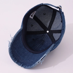Detail of vintage blue denim baseball cap showing internal stitching and adjustable metal buckle