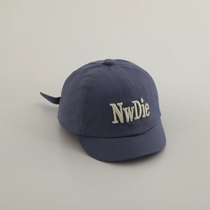 Detail of navy blue baby baseball cap featuring premium 3D letter embroidery and cotton texture