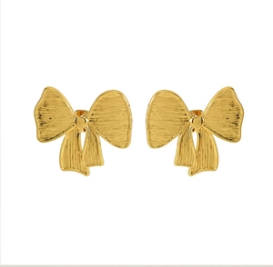 Vue macro de boucles d'oreilles nœud en or 18K brossé avec un petit détail de cœur