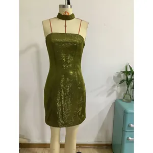 Detail view of sparkly sequin fabric on an olive green mini party dress with neck choker