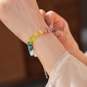 Detailed shot of a colorful natural stone beaded bracelet with a steel extender chain