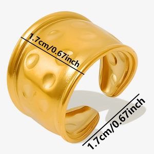 Détail d'une bague large dorée avec surface martelée géométrique et hauteur de 1,7 cm