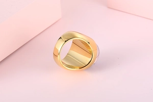 Detailed close-up of a chunky gold stainless steel ring with colorful foil glass inlay