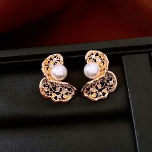 18K gold plated hollow floral earrings with white pearl and zircon accents on leather