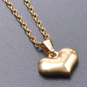 Detailed close-up of a 3D heart pendant in polished 18k gold plating on cross chain