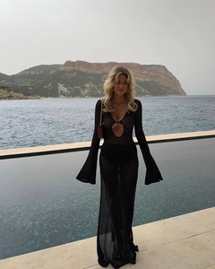 Detail of elegant black crochet maxi dress with hollow metal ring and flared sleeves