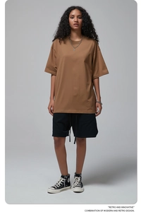 Front view of brown oversized cotton t-shirt featuring loose drop shoulder style on a model