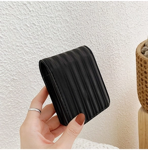 Close-up of black ripple textured mini makeup bag showing detailed leather grain