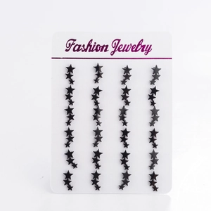 Detail of black star-shaped earrings arranged on a white Fashion Jewelry display card