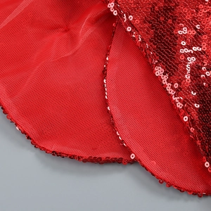 Détail macro de la broderie à paillettes rouges et texture mesh sur une robe de soirée