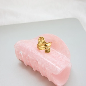 Macro detail of golden ginkgo leaf ring with polished veins and texture on gray stone