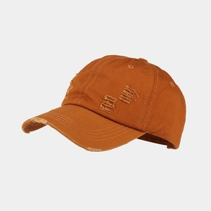 Detailed 45-degree angle of a distressed caramel cotton baseball cap with ripped details