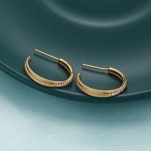 Close-up of 18K gold plated hoop earrings with twisted texture and cubic zirconia pavé
