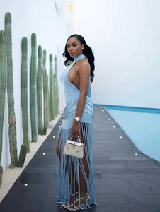 Detail of light blue halter backless dress featuring long fringe hem and poolside resort style