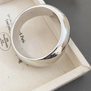 Macro shot of minimalist silver wide cuff bracelet with high-polish mirror finish in box