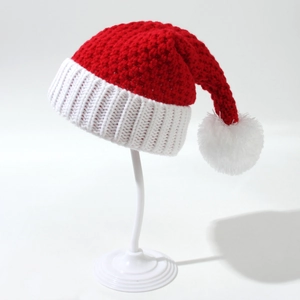 Detailed view of the red and white knit texture and plush pompom on the Christmas hat