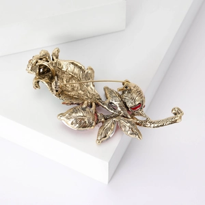 Vintage gold rose brooch with sparkling rhinestones and red enamel floral accents