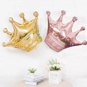 Golden and rose gold crown foil balloons for birthday party decoration on table