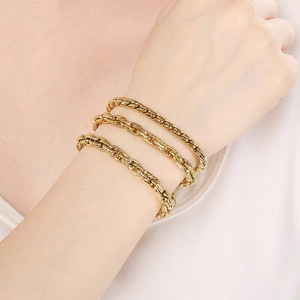Close-up of 18k gold-plated Cuban twist chain bracelets stacked on a female wrist