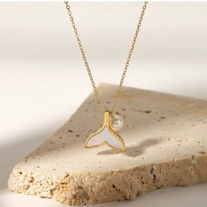 Macro view of golden mermaid tail necklace with natural mother of pearl and pearl pendant
