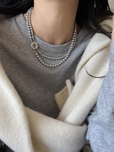 Detail of double-layer grey pearl necklace with micro-pave square clasp on a model