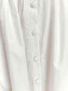 Gros plan détaillé du tissu blanc avec des boutons recouverts assortis sur la robe
