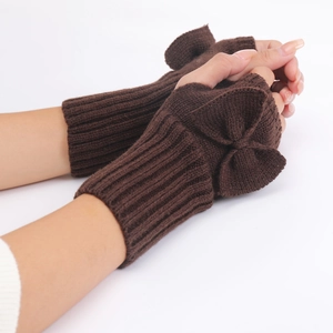 Close-up of brown knit fingerless gloves with bow detail and ribbed wrist cuffs