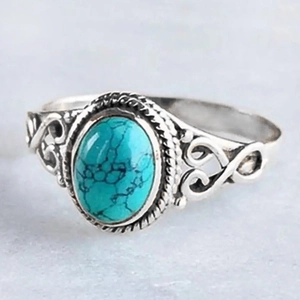 Macro shot of vintage silver ring featuring oval faux turquoise with filigree details