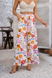 Détail d'un pantalon bohème à imprimé fleuri avec cordon de serrage et coupe large