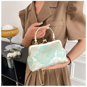 Detail of green floral embroidery and beaded handle on a traditional qipao handbag