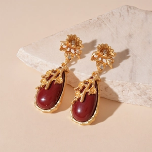 Boucles d'oreilles pendantes dorées rétro avec pierres rouges et détails de fleurs