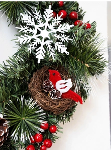 Detail of Nordic Christmas wreath with pine needles, red berries, bird nest and pine cones