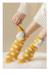 Detail of coral fleece sock with a 3D plush snowman and white polka dot pattern