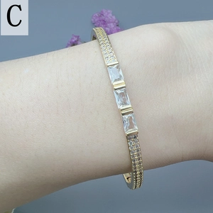 Detail of gold zircon bracelet featuring rectangular crystals and paved diamonds on wrist