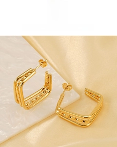 Detail of 18K gold plated multi-layer square stud earrings on marble background
