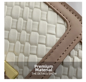 Detail of white woven leather fabric with light brown trim and precision stitching
