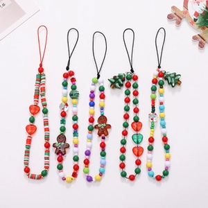 Detailed view of Christmas themed phone charms with gingerbread and tree ornaments