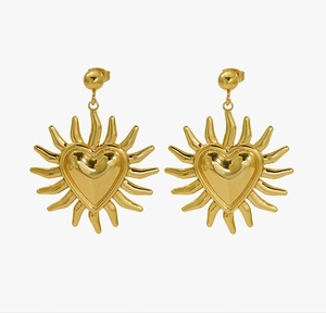 Detailed view of 18K gold heart earrings with radiant sunburst pattern and polished finish