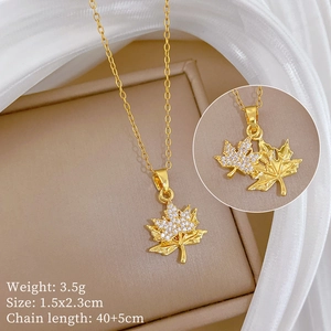 Macro detail of gold maple leaf pendant with cubic zirconia and product dimensions