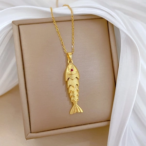 Détail du pendentif carpe koï avec œil en pierre rouge sur un collier en titane doré
