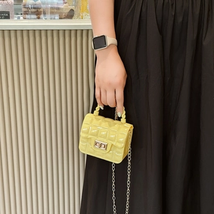 Yellow quilted PVC jelly handbag with golden chain strap for women shown by a model