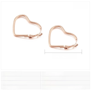 Detail view of rose gold hollow heart hoop earrings with spiral texture and measurements