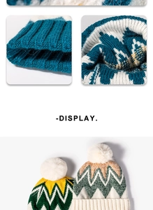 Detail of thick knit beanie with fluffy white pom-pom and geometric jacquard pattern