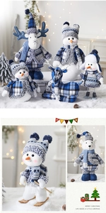 Detail of blue plaid Christmas plush dolls featuring a skiing snowman and reindeer figures