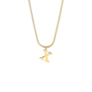 Macro detail of a 18K gold stainless steel snake chain with a minimalist letter X pendant
