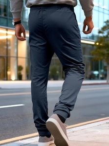 Outdoor back view of navy blue men's jogger pants showing athletic fit and fabric texture