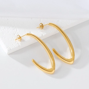 Macro detail of golden irregular V-shaped geometric earrings on elegant textured stone