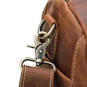 Macro detail of bronze metal hook and stitched crazy horse leather on travel bag