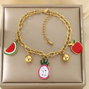 Detailed close-up of 18K gold-plated fruit charms on a chunky link chain bracelet