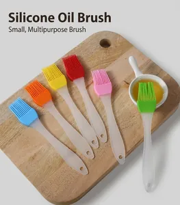 Detailed view of small silicone pastry brushes in six colors on a wooden cutting board